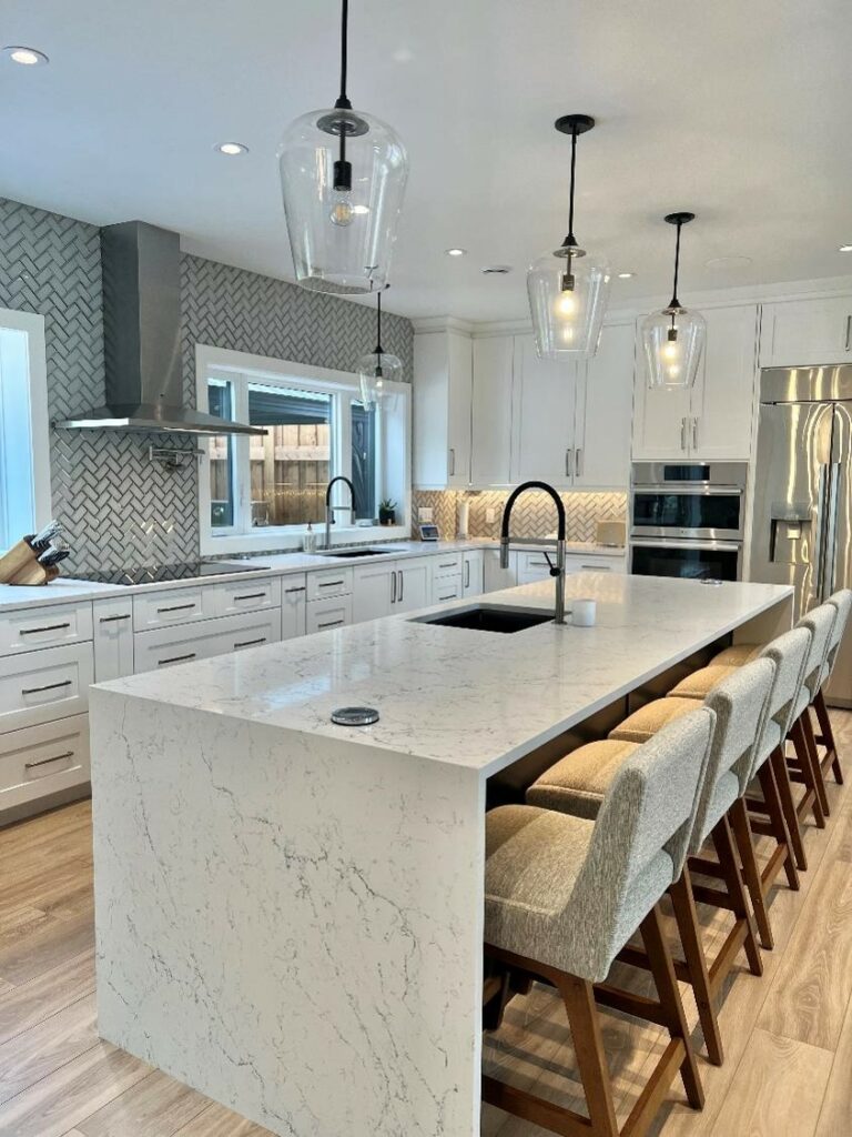 White painted Shaker kitchen cabinets with black accents and quartz countertops.